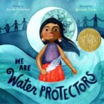 The cover of We Are Water Protectors has a girl holding a feather in a wave
